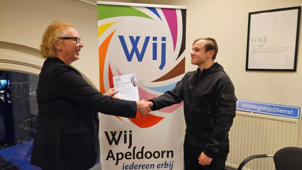 raadslid Lilian Haak feliciteert fractiestagiair Yanick met zijn getuigschrift in het fractiekantoor van WijApeldoorn