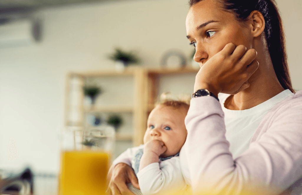bezorgde jonge moeder met haar kindje aan de ontbijttafel