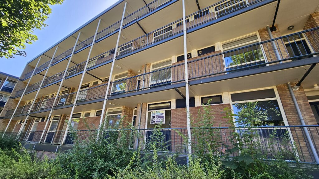 flatgebouw met galerij en een te koop bord